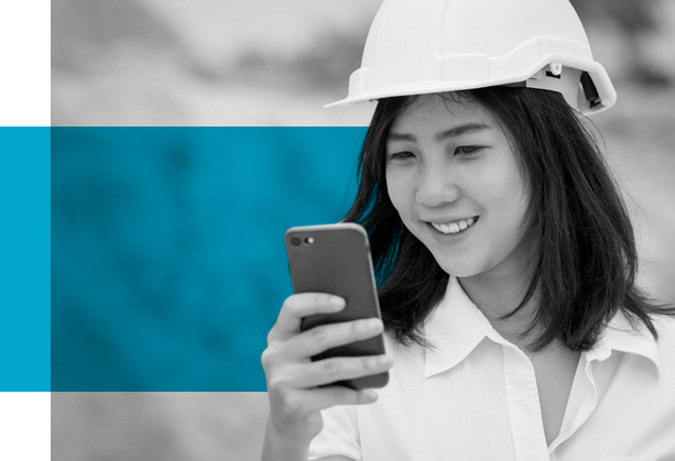 Woman in hard hat reading a Paycom content subscription